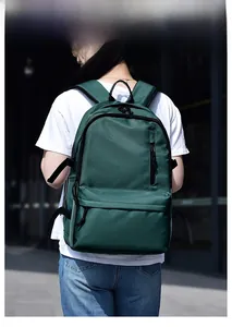 Outdoor model display of deep green waterproof laptop backpack with multiple zipper pockets