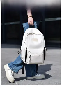 Présentation d'un sac à dos blanc minimaliste avec poches zippées noires sur un mannequin