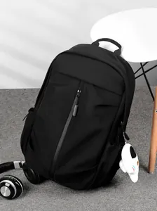 Detail of minimalist black waterproof backpack with stylish plush puppy keychain accessory
