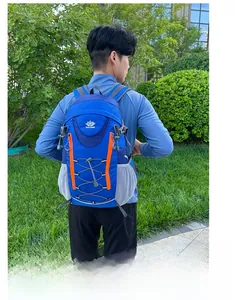 Sac à dos de randonnée bleu avec zips orange porté par un homme dans un parc vert