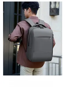 Business laptop backpack in dark grey waterproof fabric worn by a model in city setting