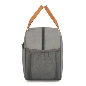Sac isotherme gris avec poignées orange et poche filet sur fond blanc pour le déjeuner
