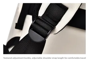 Detail view of the adjustable black plastic buckle and nylon strap on a white backpack