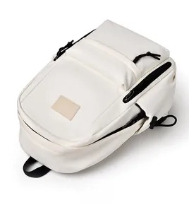 Vue de dessus d'un sac à dos minimaliste en toile blanc ivoire avec fermeture éclair noire