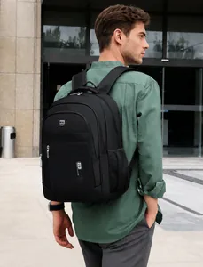 Side view of man carrying large black casual travel backpack near modern architecture