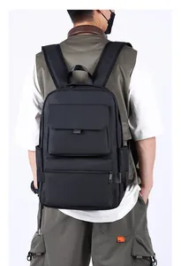 Detailed back view of a large black travel backpack with reinforced handle on a model