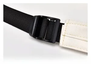 Détail de la bandoulière réglable en nylon noir et boucle blanche sur le sac à dos