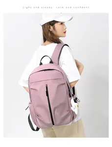 Detail view of pink nylon backpack featuring black zipper and cute astronaut charm