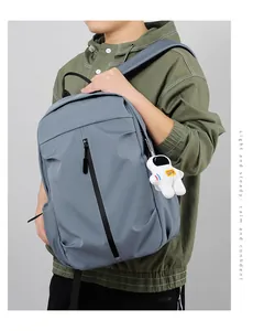Grey-blue minimalist backpack featuring vertical zipper and cute astronaut plush pendant