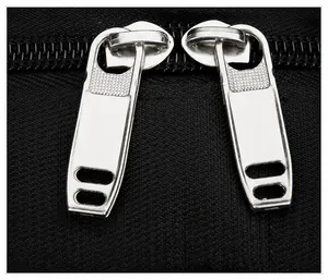 Close-up of durable double metal zippers on black high-density nylon backpack fabric
