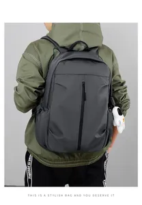 Detail of dark grey backpack on model featuring a decorative white astronaut plush charm