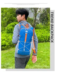 Detail of blue outdoor backpack with orange straps and mesh pocket in natural setting