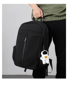 Detail of black waterproof nylon backpack with zipper pocket and astronaut charm