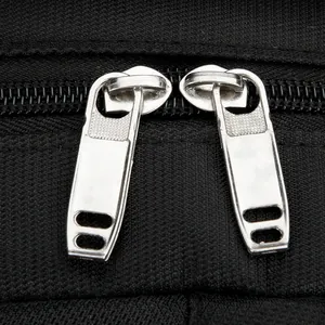 Durable dual silver metal zippers on black high-density travel backpack fabric