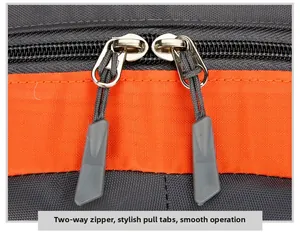 Close-up of durable two-way zippers and orange straps on a grey hiking backpack