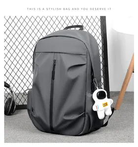 Detail view of grey casual backpack featuring vertical front zipper and astronaut keychain