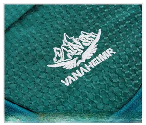 Vue rapprochée du logo VANAHEIMR brodé sur le tissu en nylon alvéolé du sac de voyage