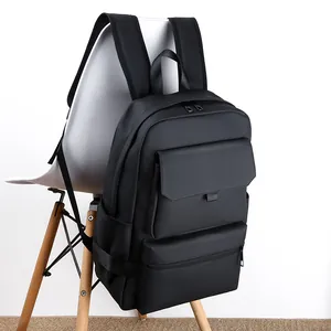 Modern black waterproof business travel backpack hanging on white chair for daily commute