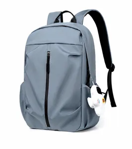Three-quarter view of a gray-blue waterproof backpack with plush astronaut charm