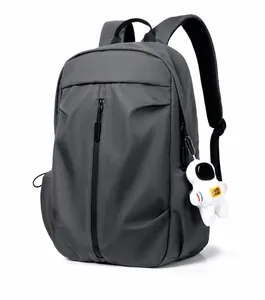 Three-quarter side view of a dark grey casual backpack with astronaut pendant detail