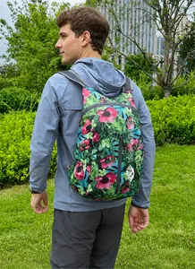 Lifestyle-Foto eines faltbaren Rucksacks mit Blumenmuster und grauen Trägern