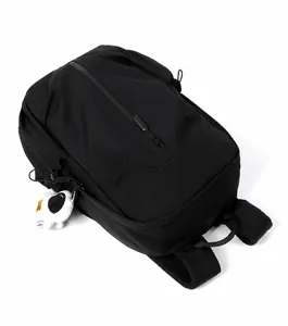 Close-up of black waterproof nylon backpack featuring a white astronaut plush keychain