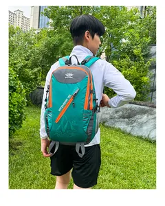 Outdoor enthusiast wearing a green 40L hiking backpack with orange accents in nature
