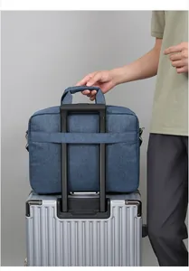 Blue laptop bag with back strap secured on a silver suitcase handle for travel ease