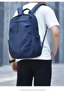 Detail view of water-resistant navy backpack with USB port and vertical front zipper pocket