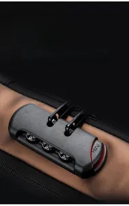 Detail view of the anti-theft three-digit combination lock on a brown crossbody bag