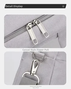 Detail view of smooth metal zippers and detachable shoulder strap hooks on a gray laptop bag