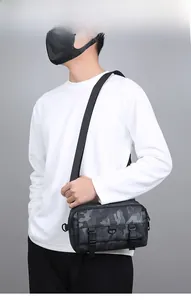 Detail of black camouflage crossbody bag featuring tactical dual buckle and metal loops