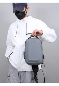 Detail view of anti-theft combination lock and USB charging port on grey crossbody chest bag