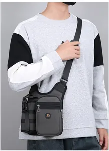 Seitenansicht der dunkelgrauen taktischen Umhängetasche mit Logo an einem Model