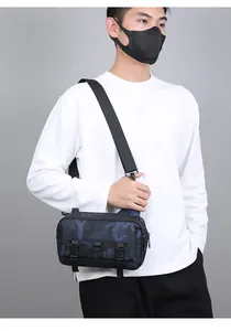 Side view of blue camo crossbody bag on model showing compact nylon build and strap