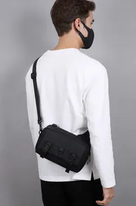 Detail view of water-resistant matte black crossbody bag featuring secure buckle closure