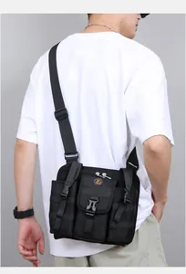 Detail of black tactical travel crossbody bag featuring utility pockets and wide strap