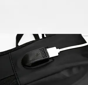 Detalle del puerto de carga USB externo en un bolso bandolera negro impermeable