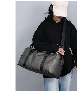 Détail de la poignée renforcée et des crochets métalliques sur un grand sac de sport