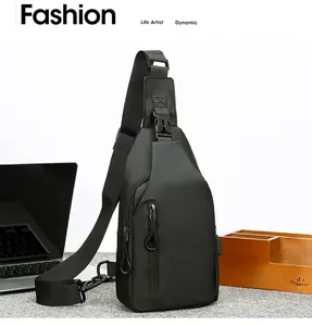 Detalle de bandolera de nailon negro con puerto de carga USB integrado para hombres