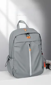 Detailed view of grey water-resistant nylon backpack with orange zippers for commuting