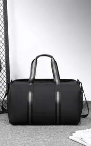 Detail of waterproof travel bag featuring striped handles and a dedicated shoe compartment