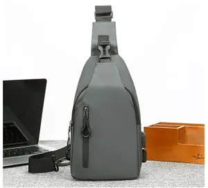 Vista detallada de la mochila de pecho gris con puerto USB y correa ajustable