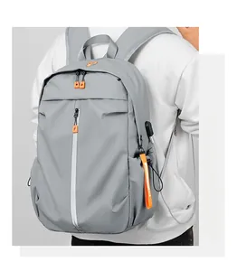 Detail of grey waterproof backpack showing side USB port and orange zipper accents