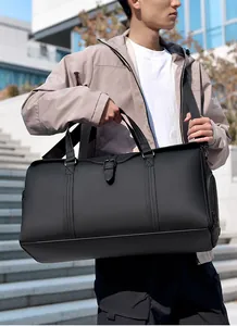 Close-up of waterproof black travel bag showing matte texture and reinforced shoulder strap