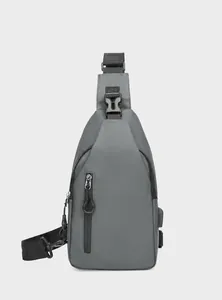Detalle frontal de bandolera gris para exterior con puerto USB y tejido impermeable