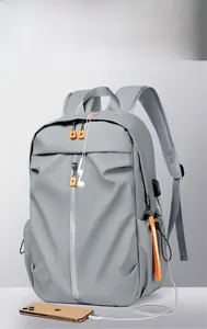 Detail of grey waterproof backpack showing side USB charging port and interior cable