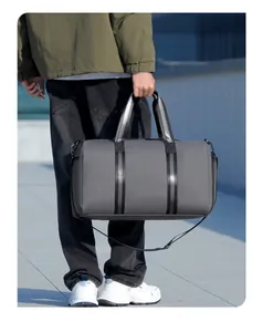 Gray waterproof duffel bag featuring reinforced black handles and side shoe compartment