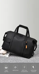 Detail showing high-capacity black fitness bag with waterproof fabric and orange zippers
