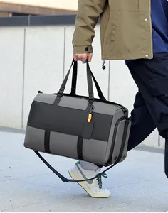Detailed side view of grey waterproof travel bag with orange tag and adjustable strap
